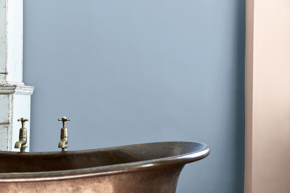 Badezimmer mit blauer Wandfarbe und Kupferbadewanne